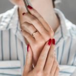 woman in red manicure and gold ring