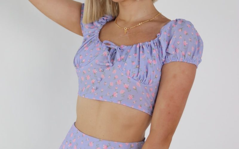woman in pink and white polka dot crop top and blue denim shorts