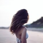 woman standing wearing white bra in selective focus photography