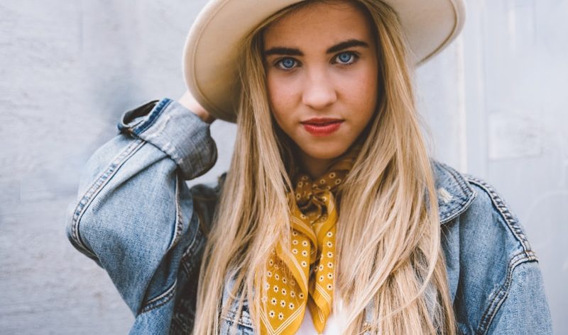 woman wearing blue denim jacket and white hat