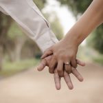 shallow focus photography of two person holding hands