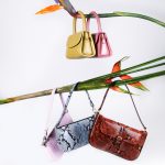 brown leather sling bag hanged on green and red clothes hanger
