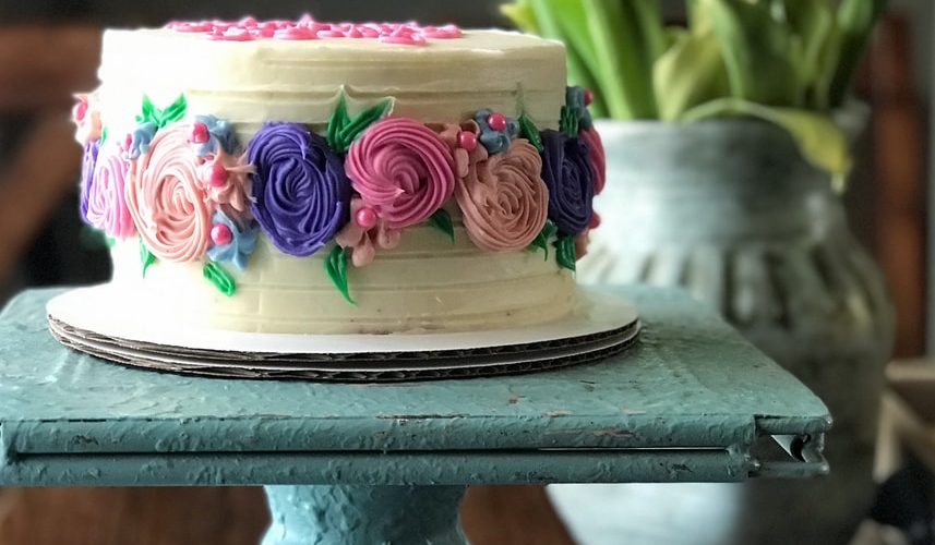 pink and white floral cake on black stand