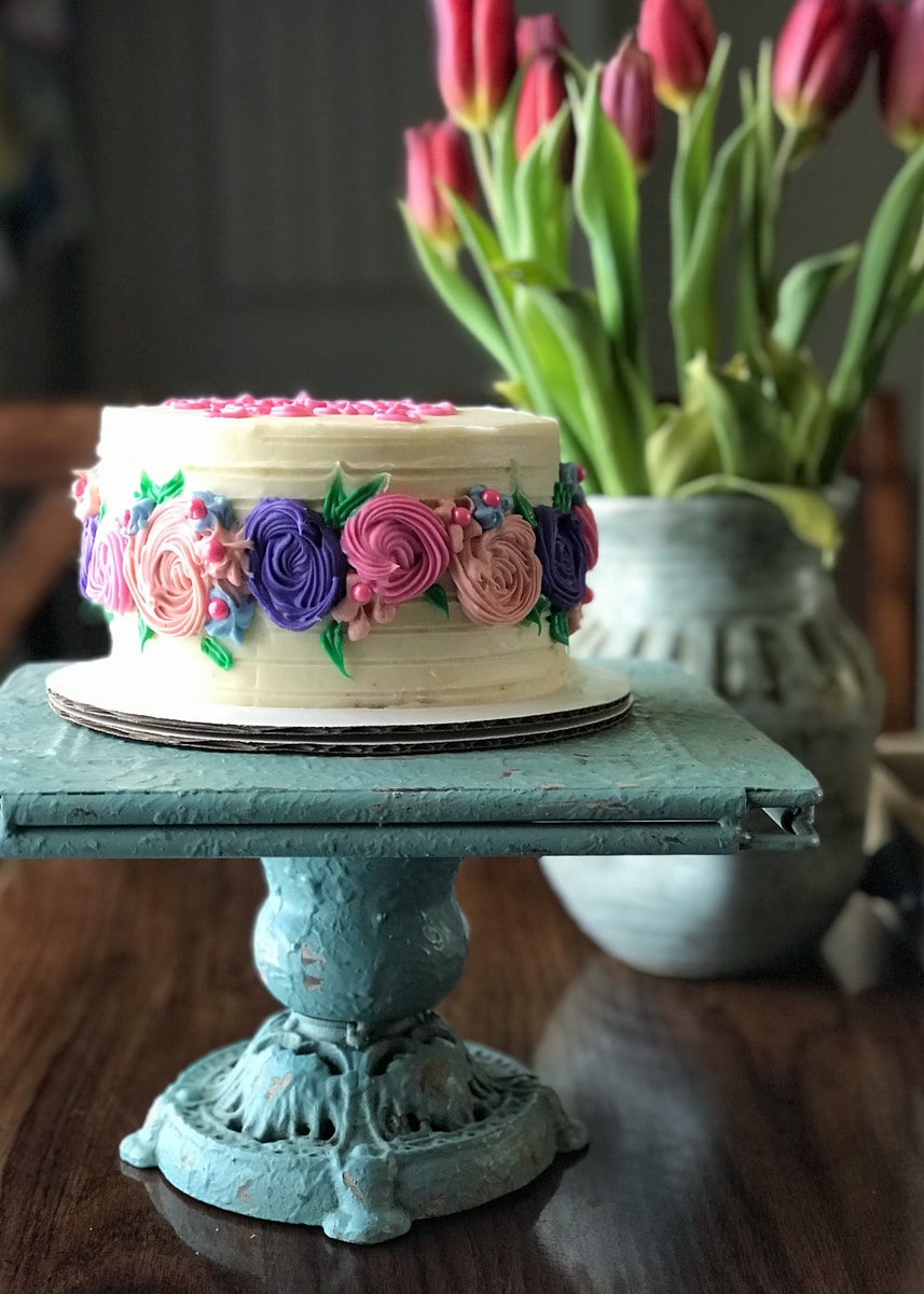pink and white floral cake on black stand