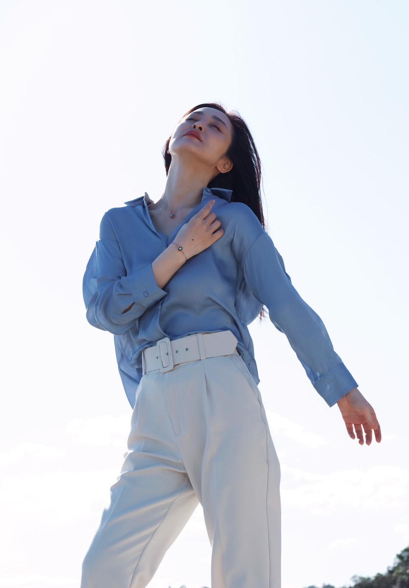 woman in blue long sleeve shirt and white pants