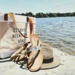 hat, sandals, and bag near water