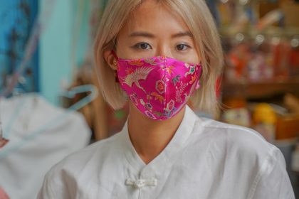 girl in white button up shirt with pink and white floral mask
