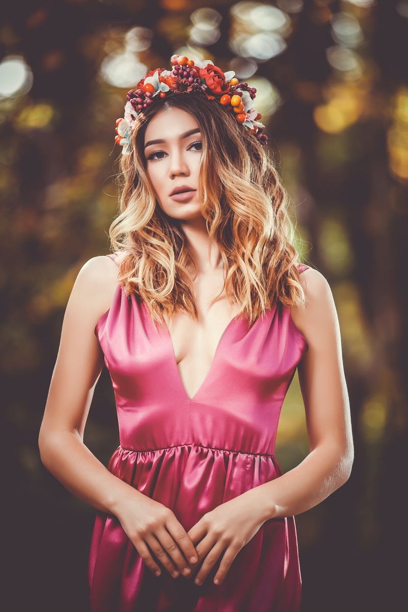 woman in pink V-neck sleeveless dress wearing flower crown in bokeh photography
