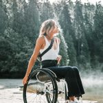 woman riding wheelchair near trees