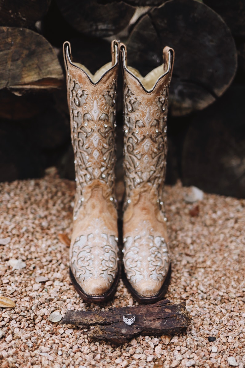 pair of brown leather cowboy boots near plank