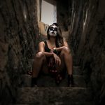 woman wearing skull face paint sitting on stairs