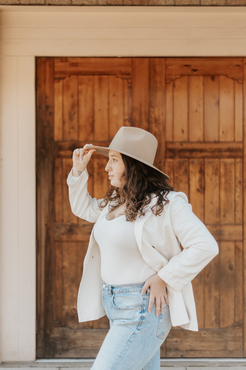 woman in white long sleeve shirt and blue denim daisy dukes wearing white cowboy hat