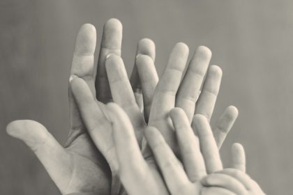 grayscale photo of family's hands