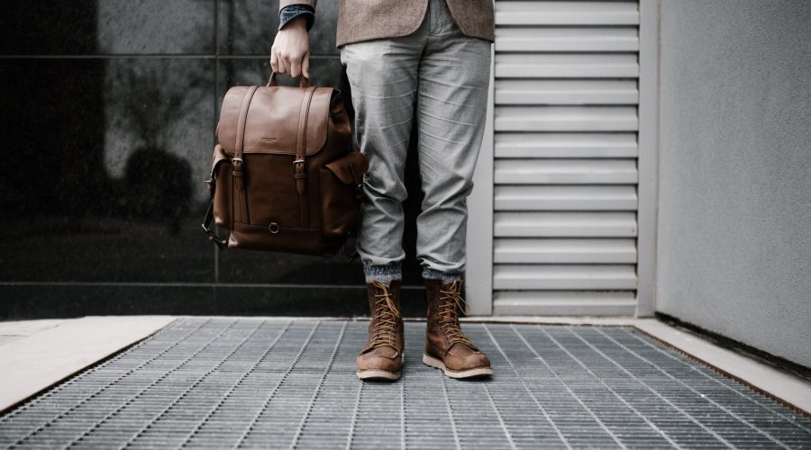 person holding brown leather bag