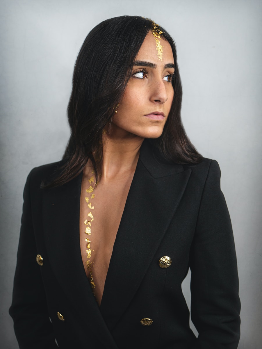 woman in black blazer and gold necklace