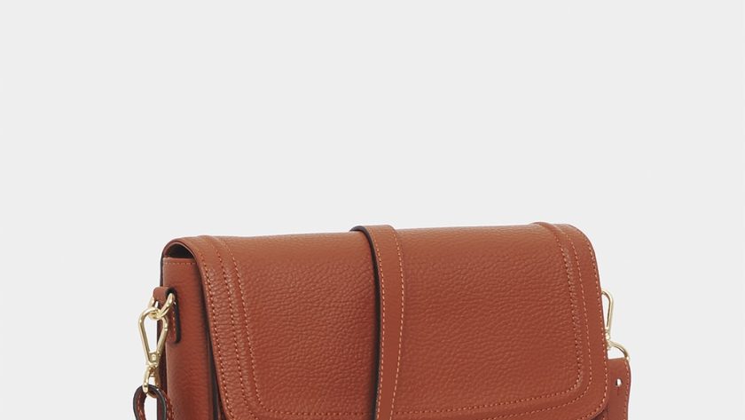 brown leather sling bag on white background