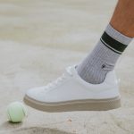 person wearing white nike sock and white nike low top sneaker