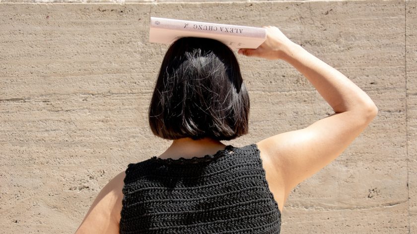 woman holding a book on top of her head